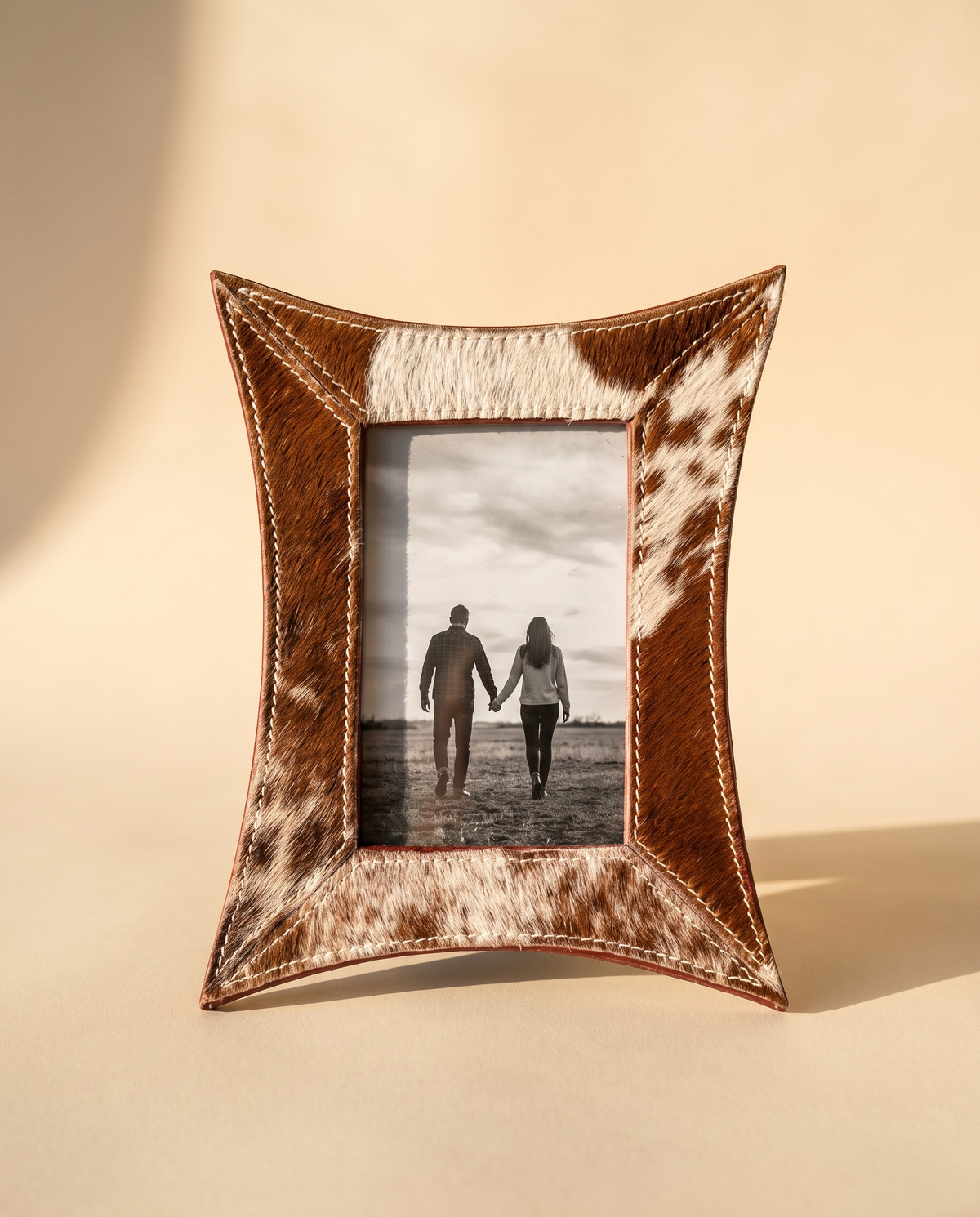 Curved hair-on leather photo frame holding a couple's photo