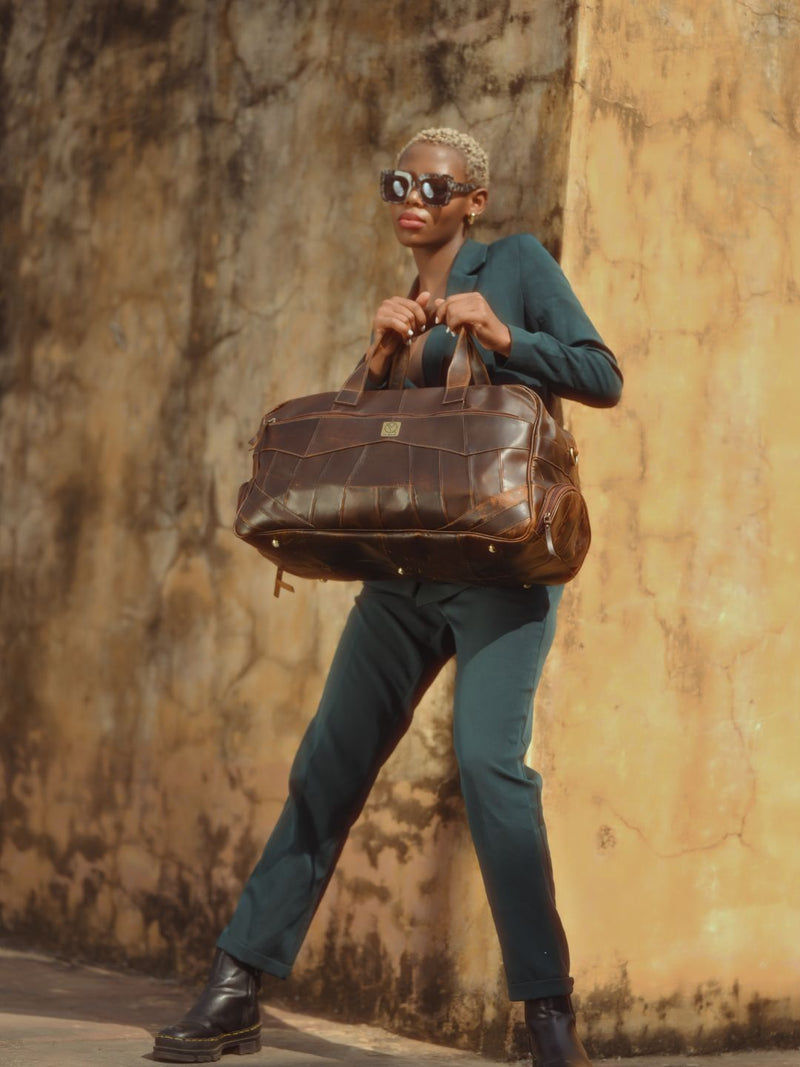 Brown leather duffle bag styled for business travel by Ya Qalbi