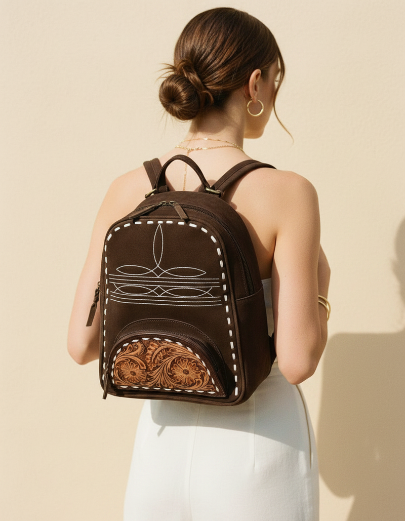 Dark brown suede backpack with white boot stitch embroidery, buckstitch lacing and tooled leather floral front pocket