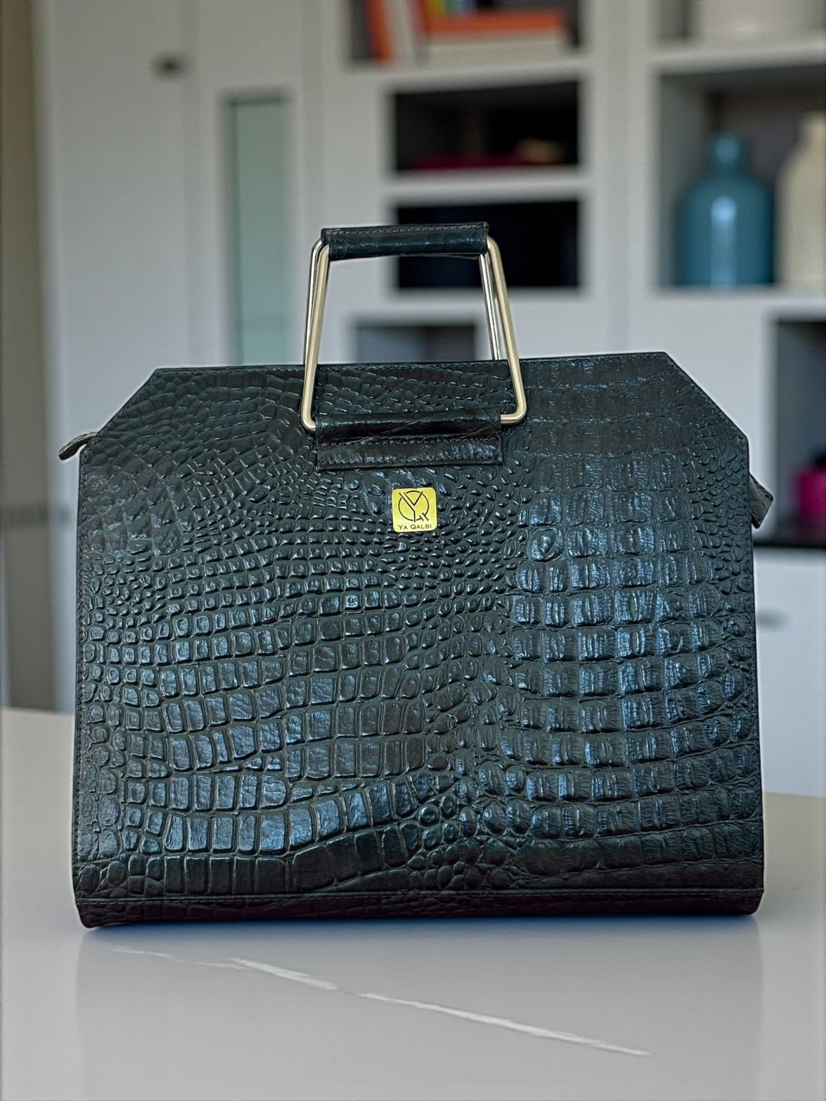 Navy croc leather laptop bag on a desk