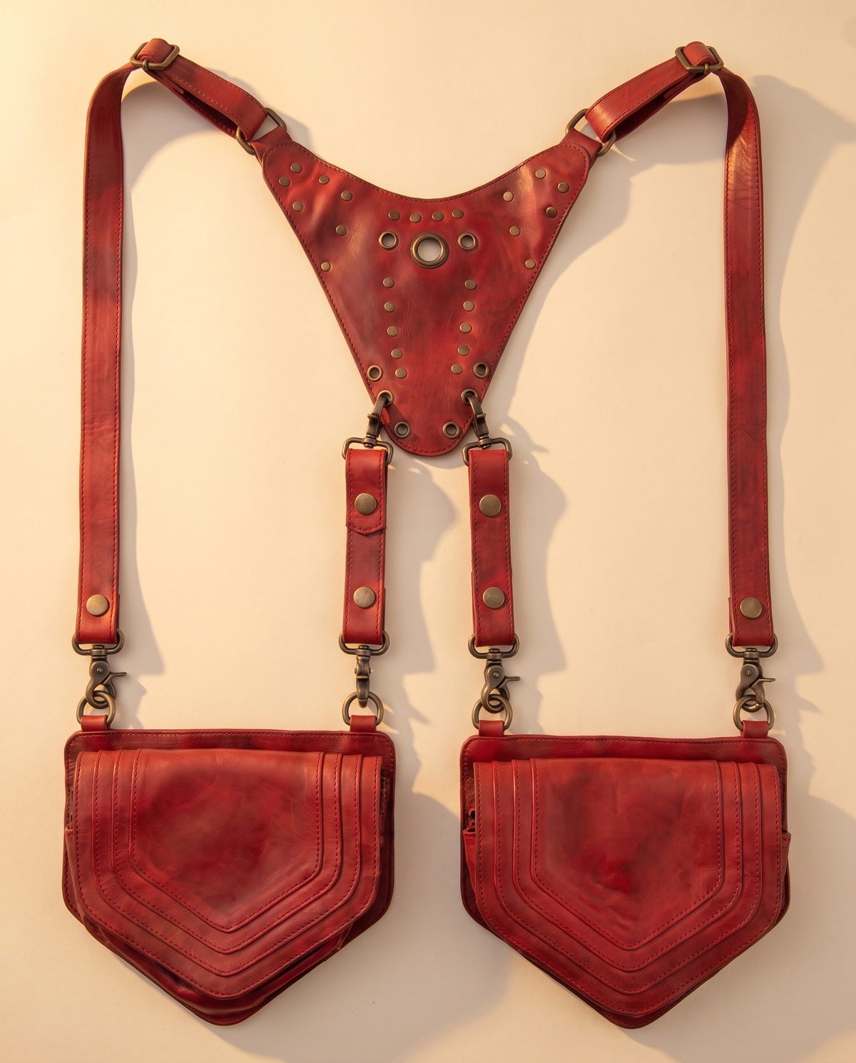 Red leather harness bag with two detachable pouches, front view, by Ya Qalbi