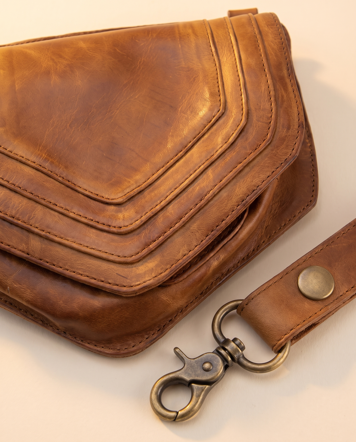 Tan leather harness bag with two detachable pouches, by Ya Qalbi