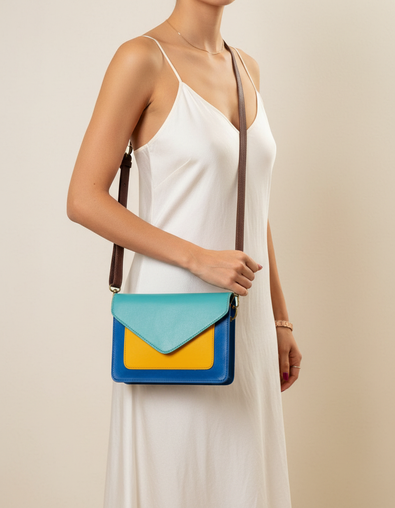 Woman wearing turquoise and yellow leather envelope crossbody