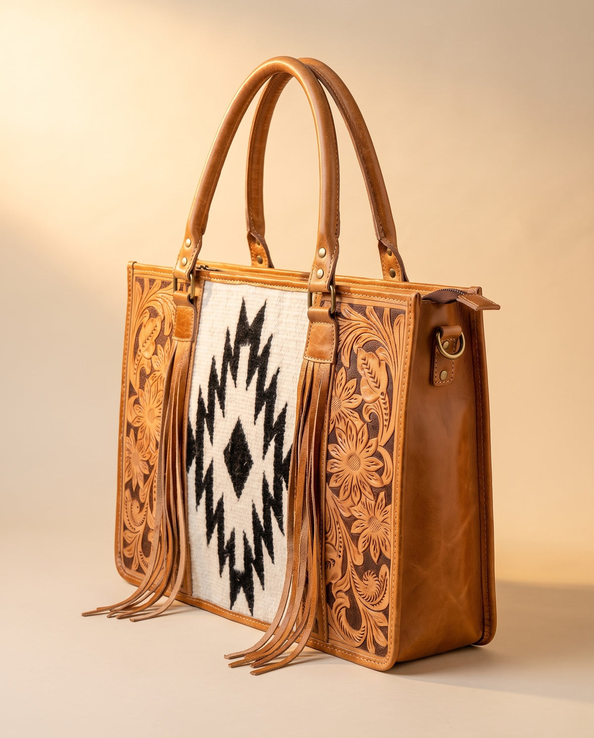 Black Aztec weave hand-tooled leather tote with fringe, angled view, by Ya Qalbi