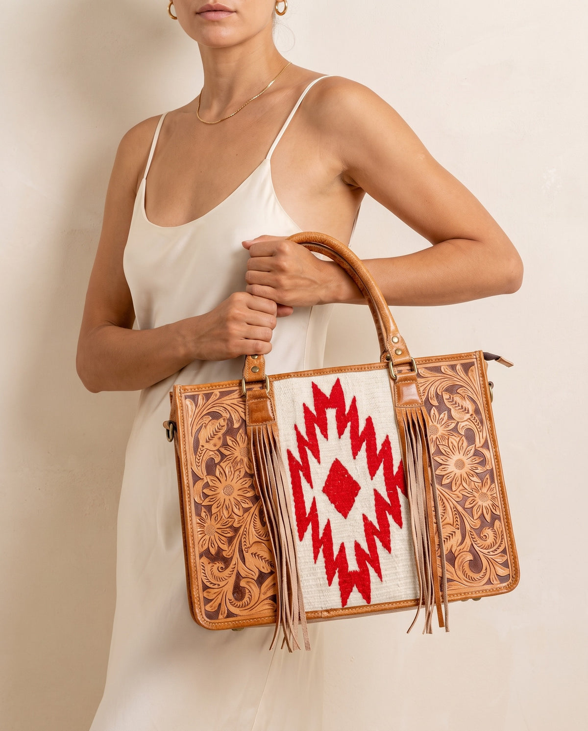 Red Aztec weave hand-tooled leather tote with fringe, worn by a model, by Ya Qalbi