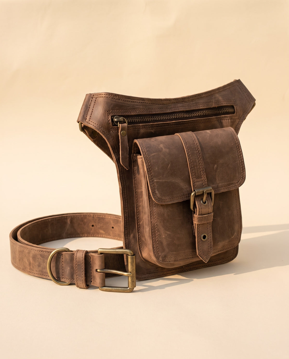 Brown leather leg bag with buckle pocket, angled view, by Ya Qalbi