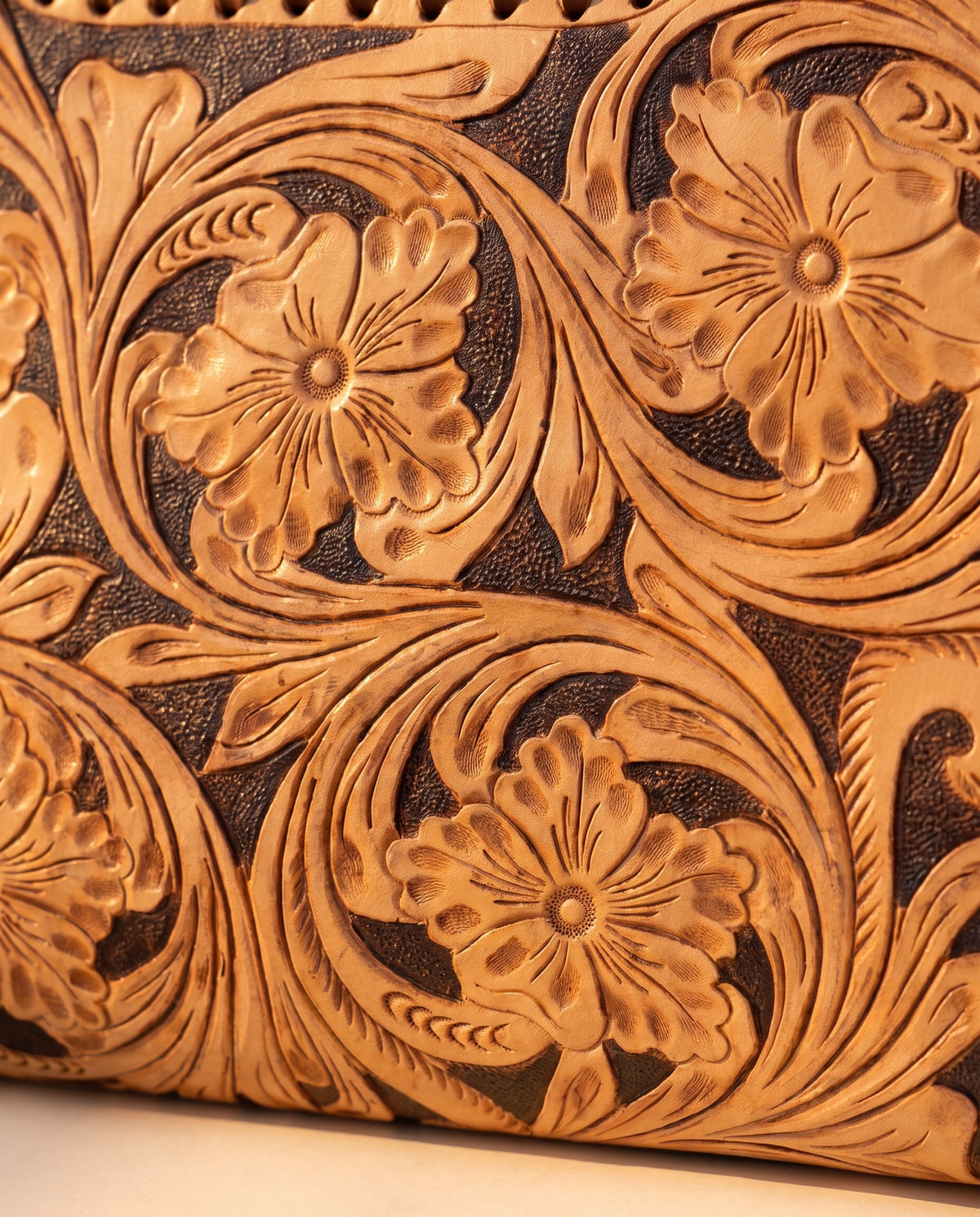 Brown hand-tooled leather bag with cut-out handle, detail close-up, by Ya Qalbi