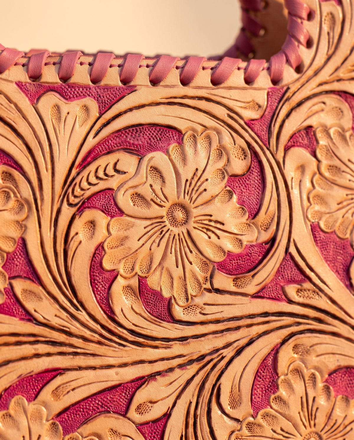 Pink hand-tooled leather bag with cut-out handle, detail close-up, by Ya Qalbi