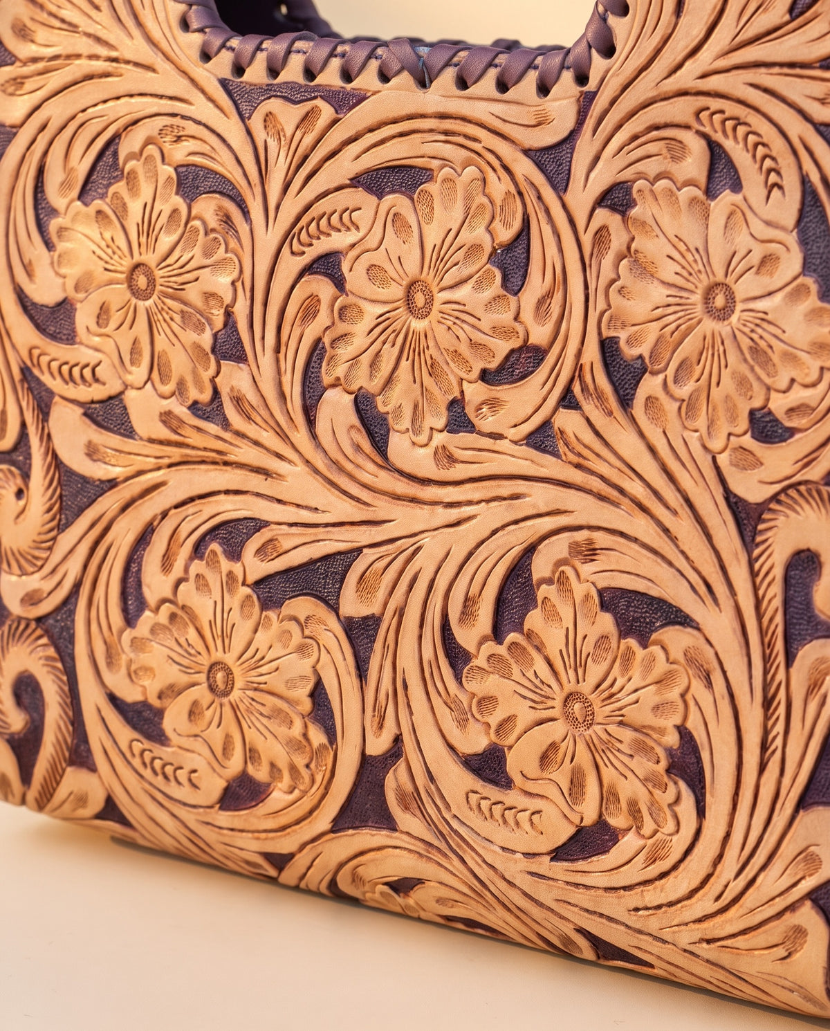 Purple hand-tooled leather bag with cut-out handle, detail close-up, by Ya Qalbi