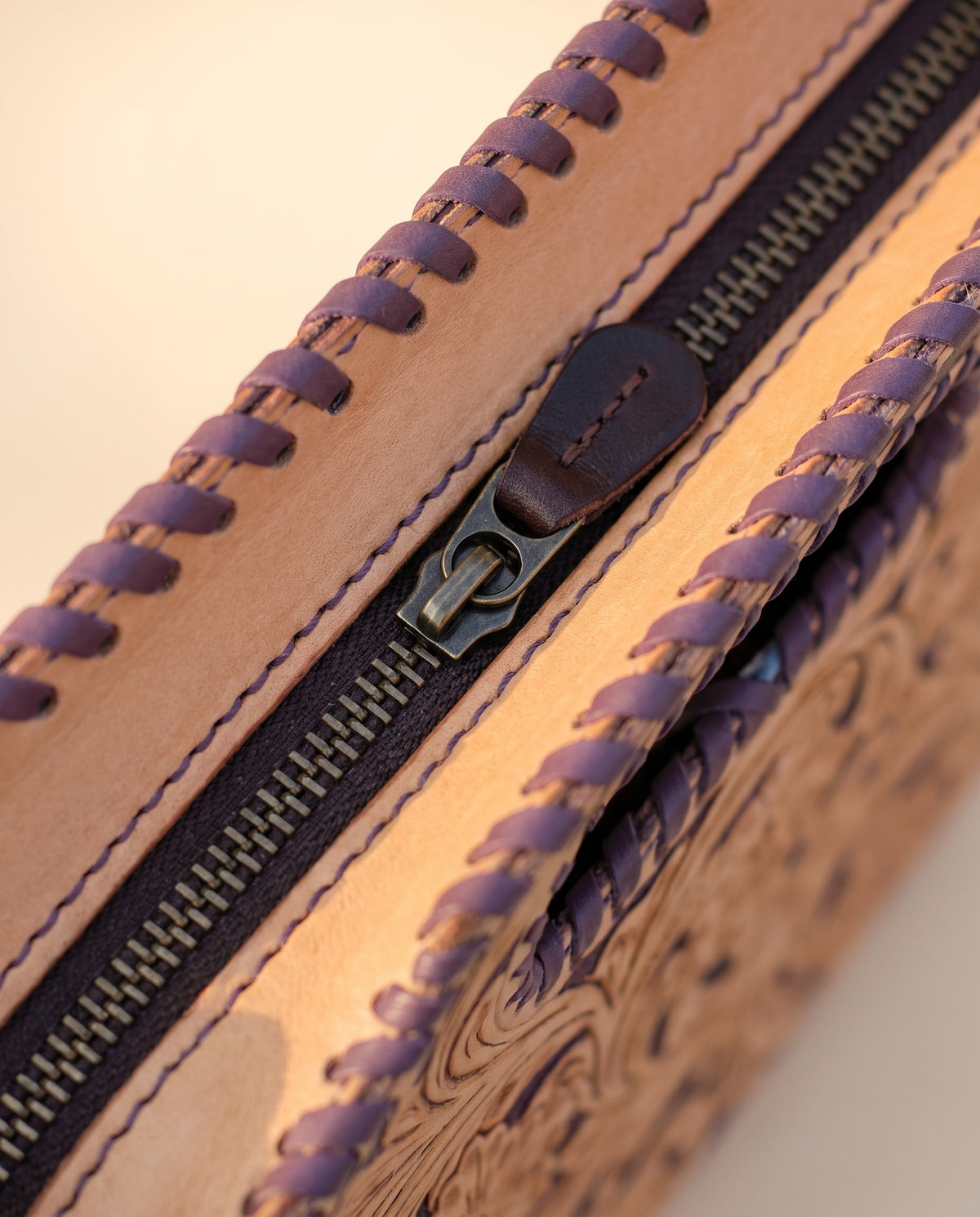 Purple hand-tooled leather bag with cut-out handle, detail close-up, by Ya Qalbi