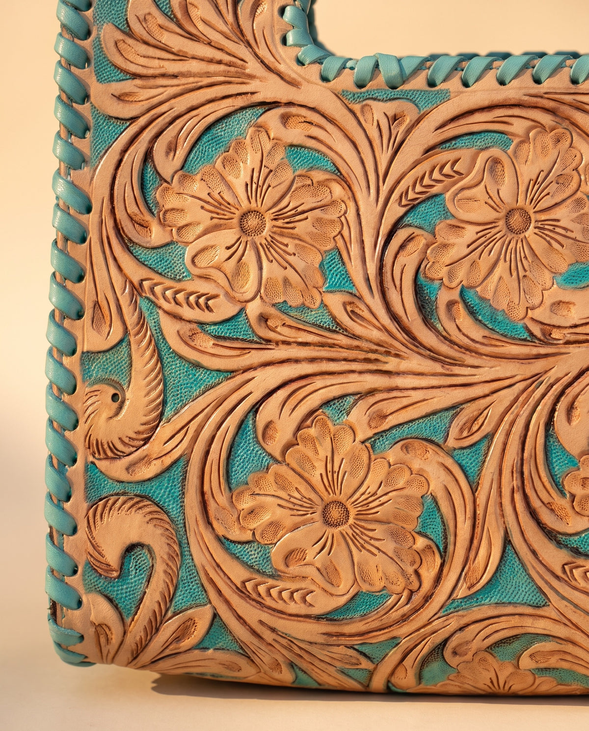 Turquoise hand-tooled leather bag with cut-out handle, detail close-up, by Ya Qalbi