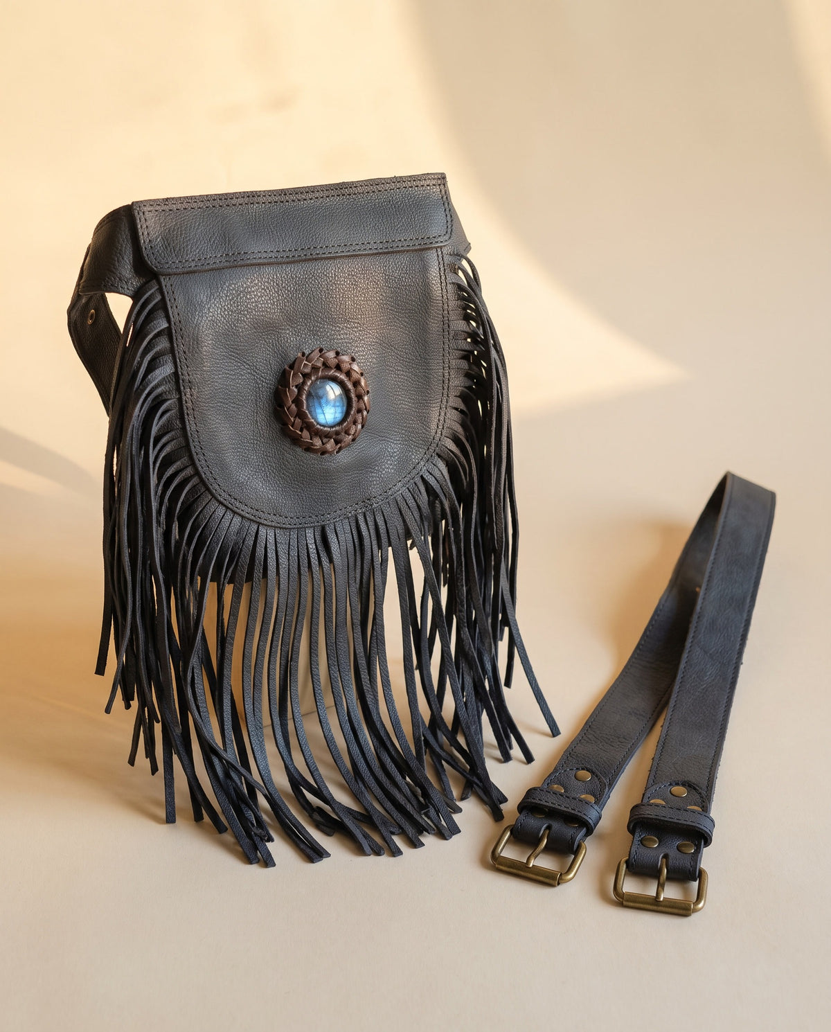 Black fringe leather hip bag with stone, angled view, by Ya Qalbi