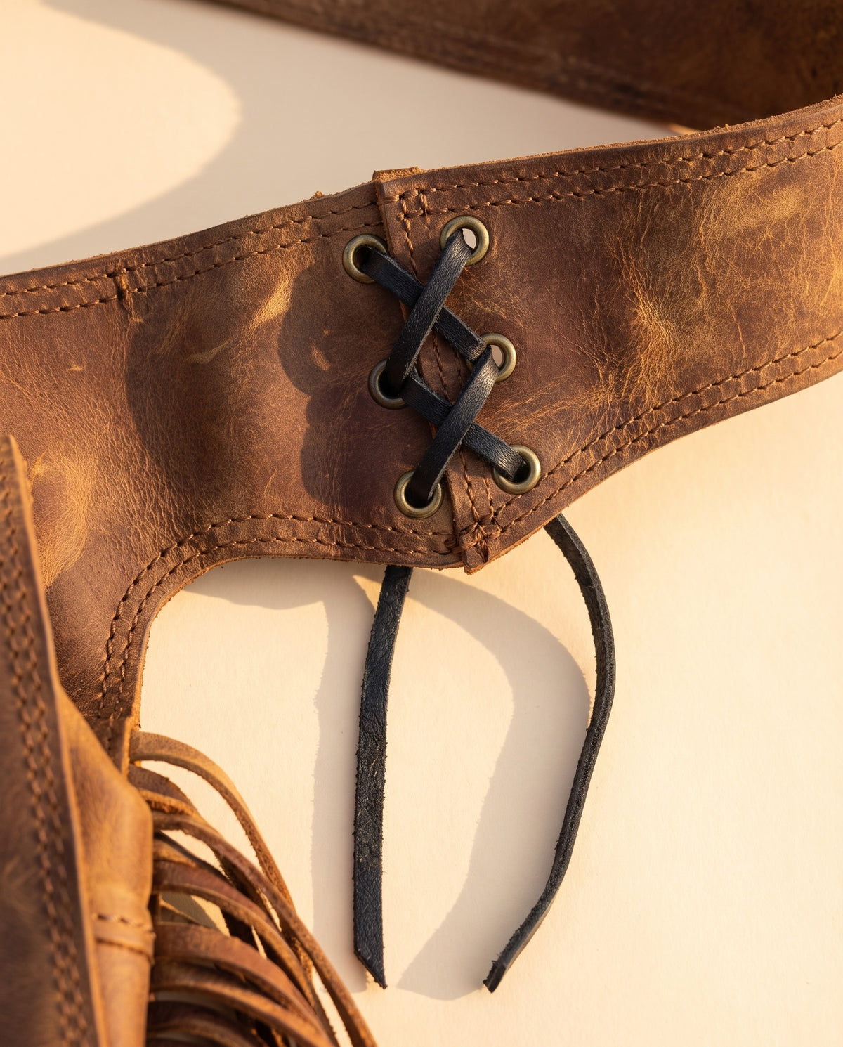 Brown fringe leather hip bag with stone, detail close-up, by Ya Qalbi