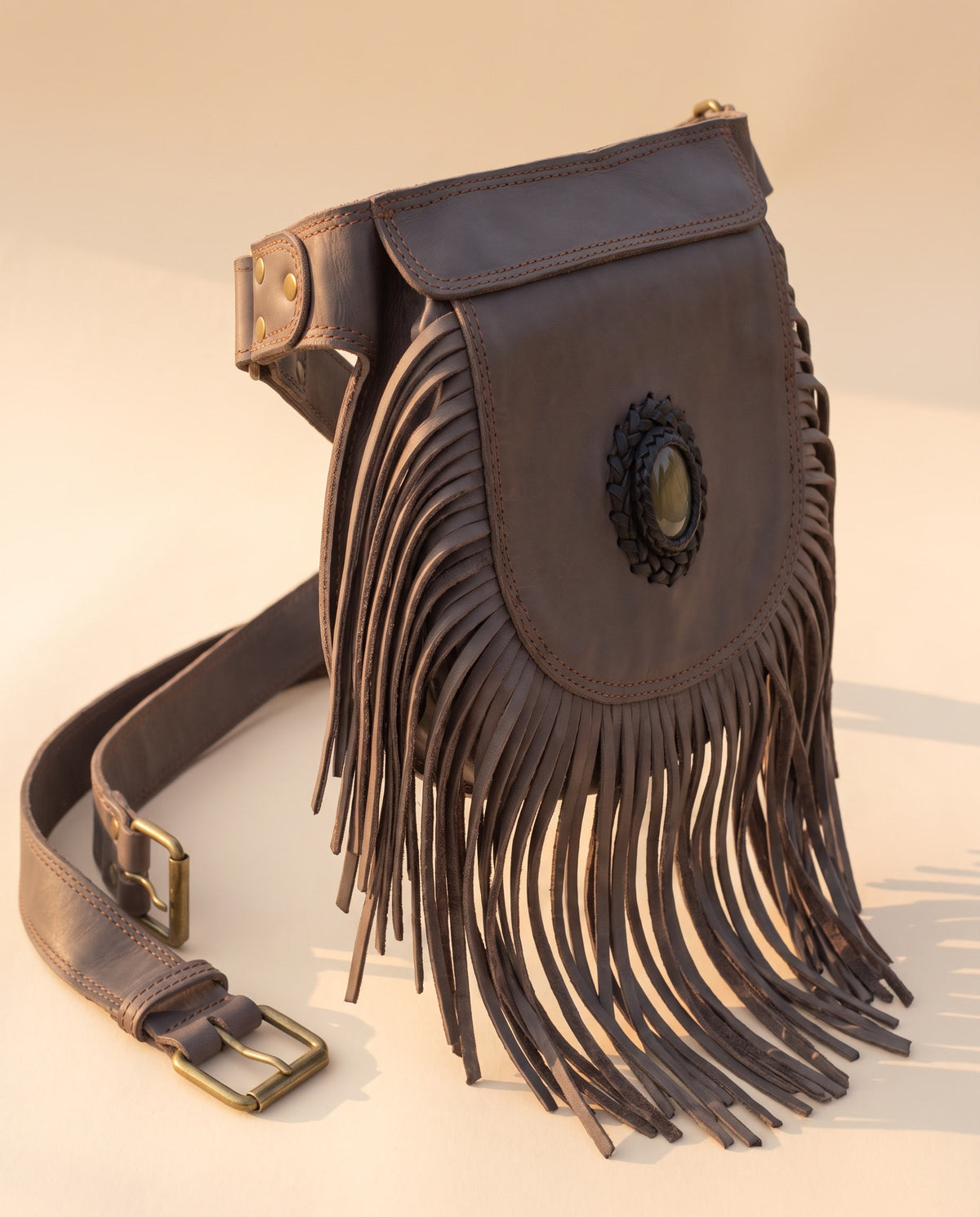 Grey fringe leather hip bag with stone, angled view, by Ya Qalbi