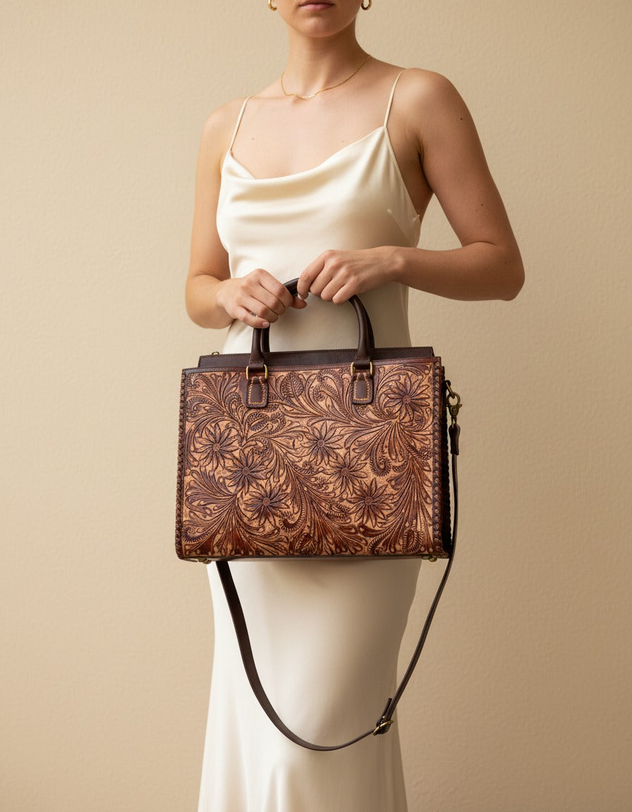 Brown hand-tooled floral leather tote, worn by a model, by Ya Qalbi