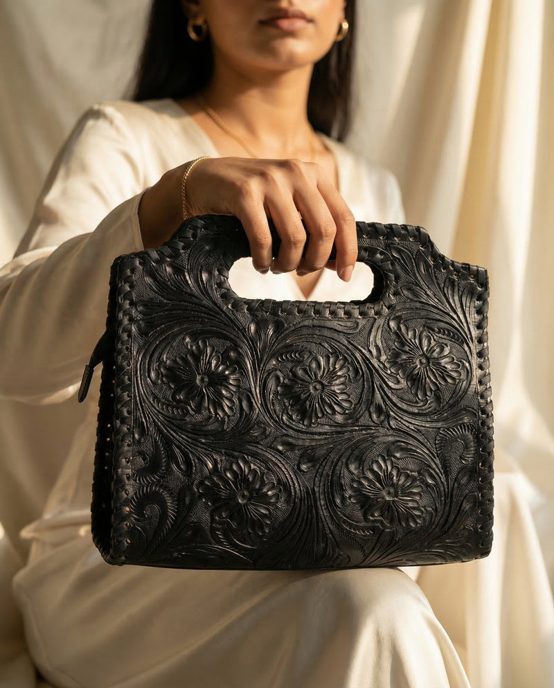 Black artisan leather clutch tote with floral hand-tooling by Ya Qalbi