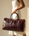 Maroon crocodile texture leather duffle bag by Ya Qalbi