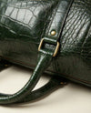 Green croc-textured leather travel bag with brass studs by Ya Qalbi
