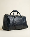 Blue croc-textured leather travel bag with brass studs by Ya Qalbi