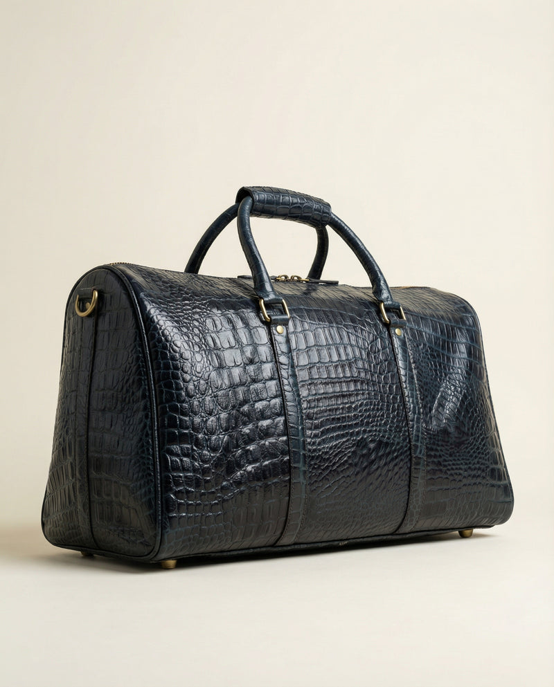 Blue croc-textured leather travel bag with brass studs by Ya Qalbi