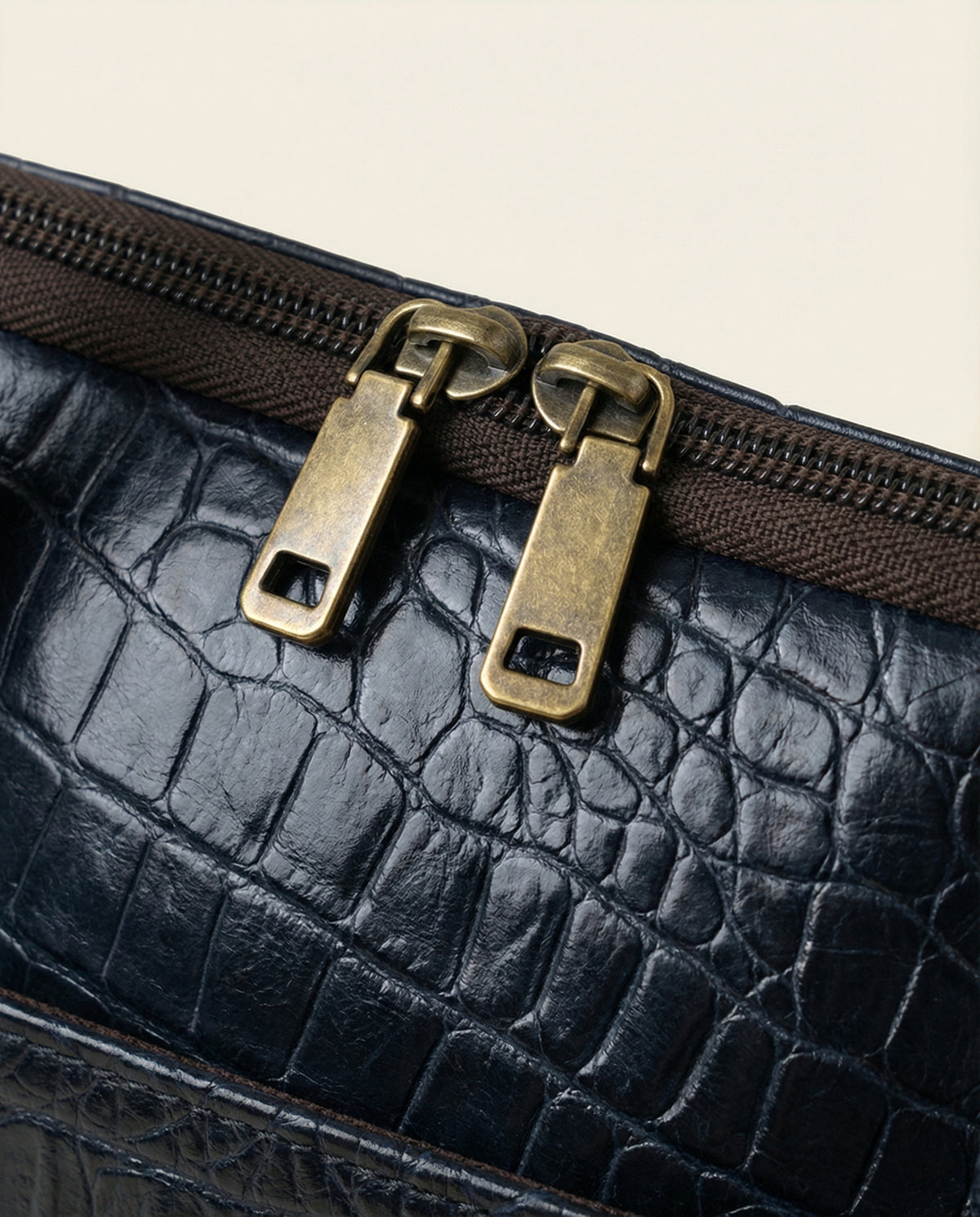 Close-up of double zip pulls on navy croc leather