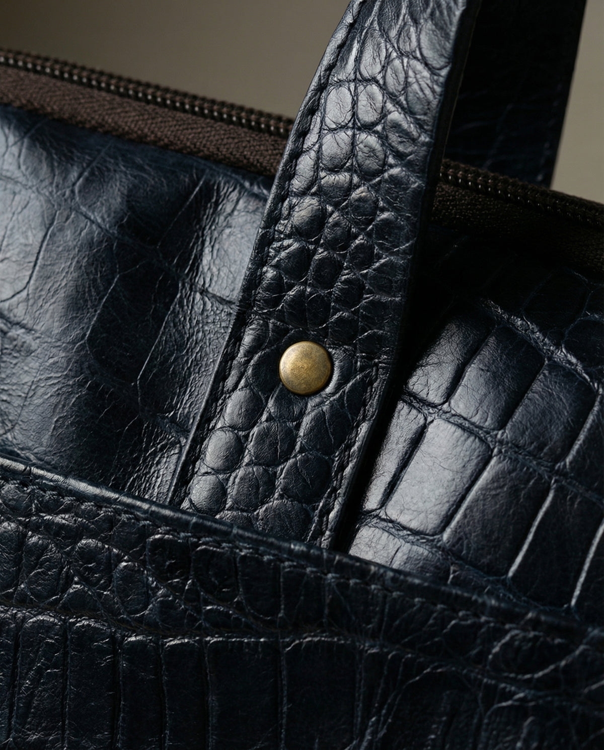 Close-up of rolled handle on navy croc leather