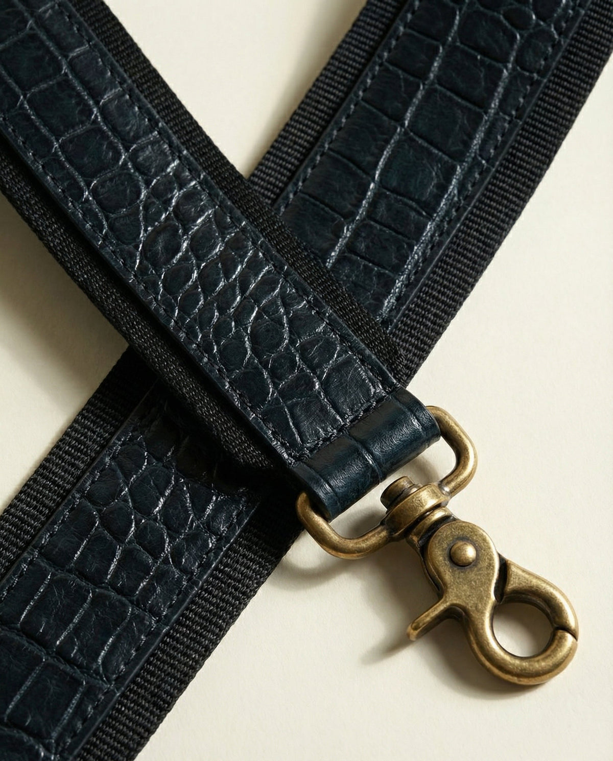 Close-up of shoulder strap clip on navy croc leather