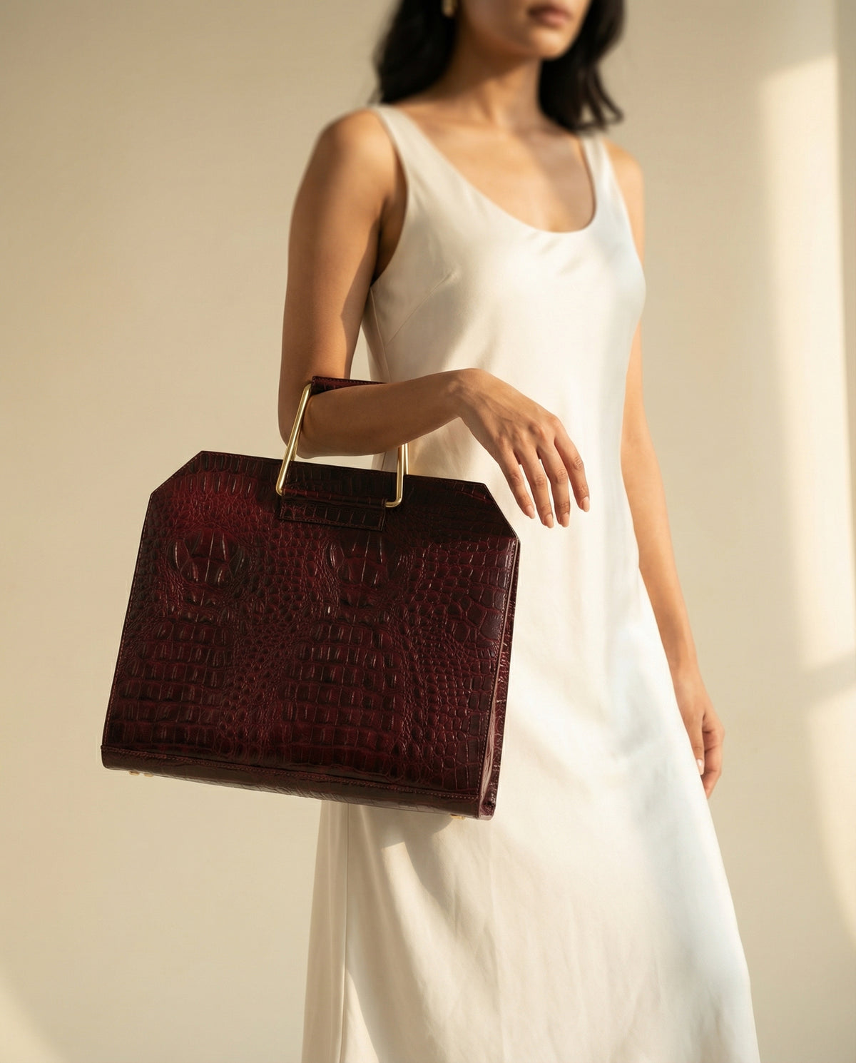Woman holding wine croc leather laptop bag