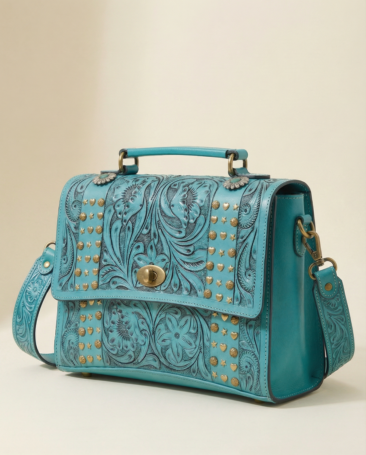 Side angle of turquoise tooled leather satchel with top handle by Ya Qalbi