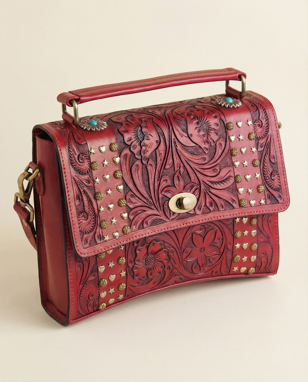 Side angle of red tooled leather crossbody satchel with top handle by Ya Qalbi