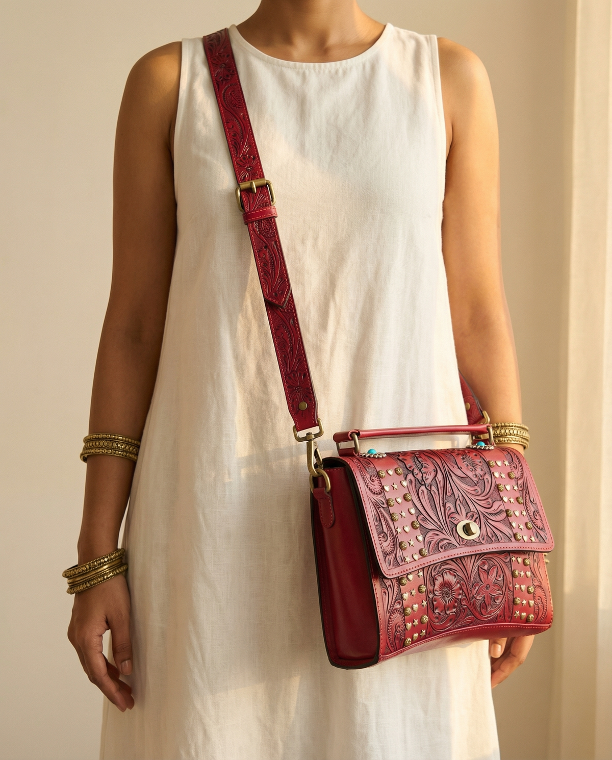 Red tooled leather crossbody satchel worn by model by Ya Qalbi