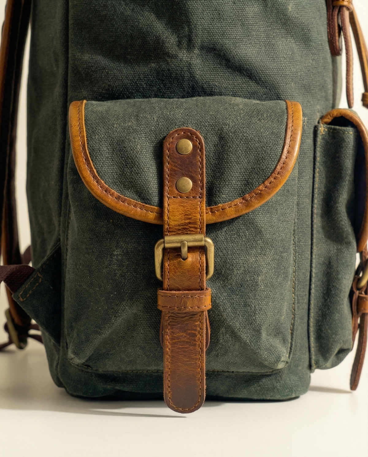 Close-up of green buckle side pocket with tan leather trim