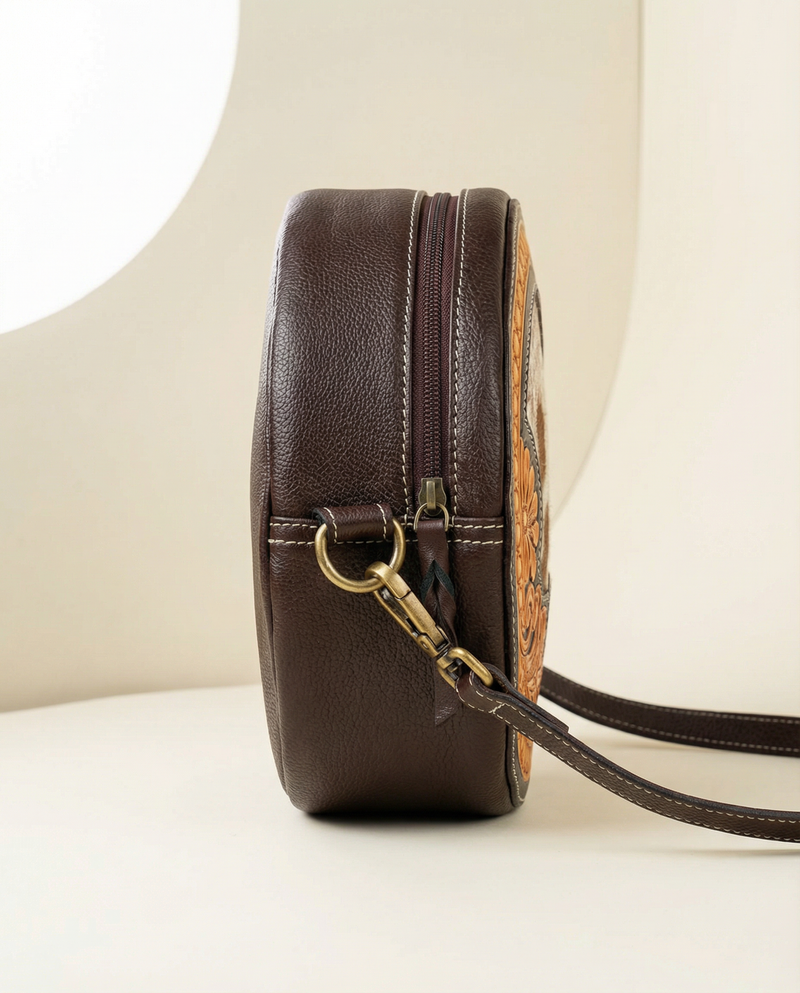 Hand-tooled hair-on leather circular crossbody bag by Ya Qalbi