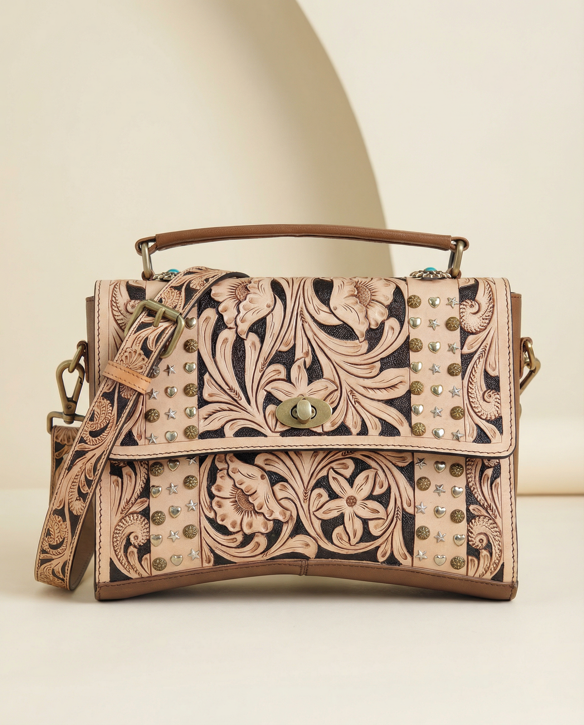 Tan tooled leather crossbody satchel with brass studs, front view, by Ya Qalbi