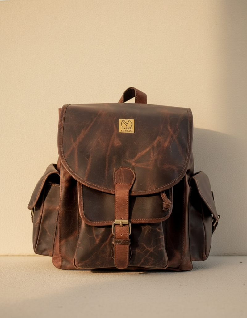 Full-grain brown leather backpack with brass lock by Ya Qalbi