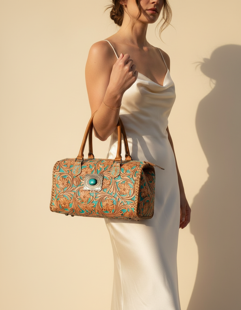 Turquoise and tan hand-tooled leather barrel bag with stone, worn by a model, by Ya Qalbi