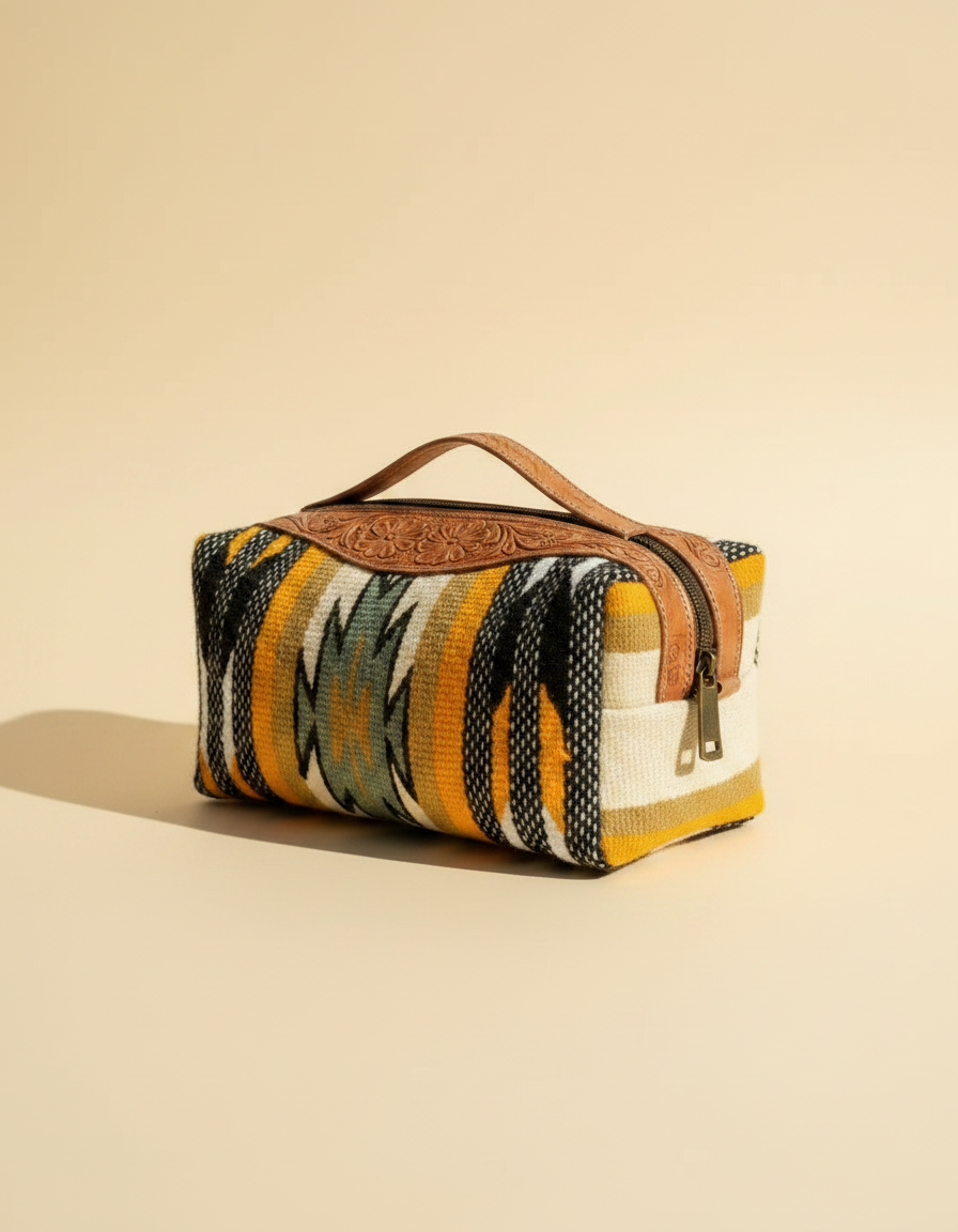 Hand-tooled leather makeup bag with hair-on cowhide and brass hardware
