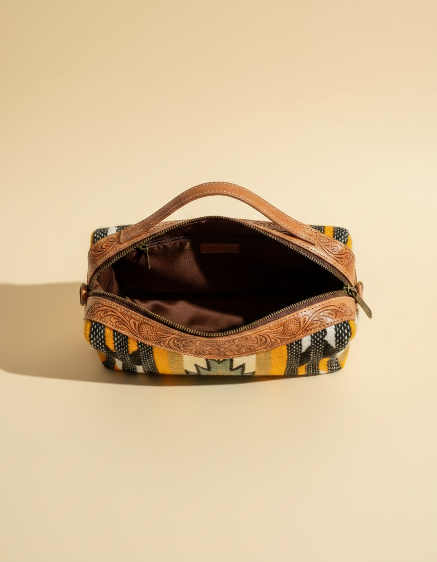 Hand-tooled leather makeup bag with hair-on cowhide and brass hardware