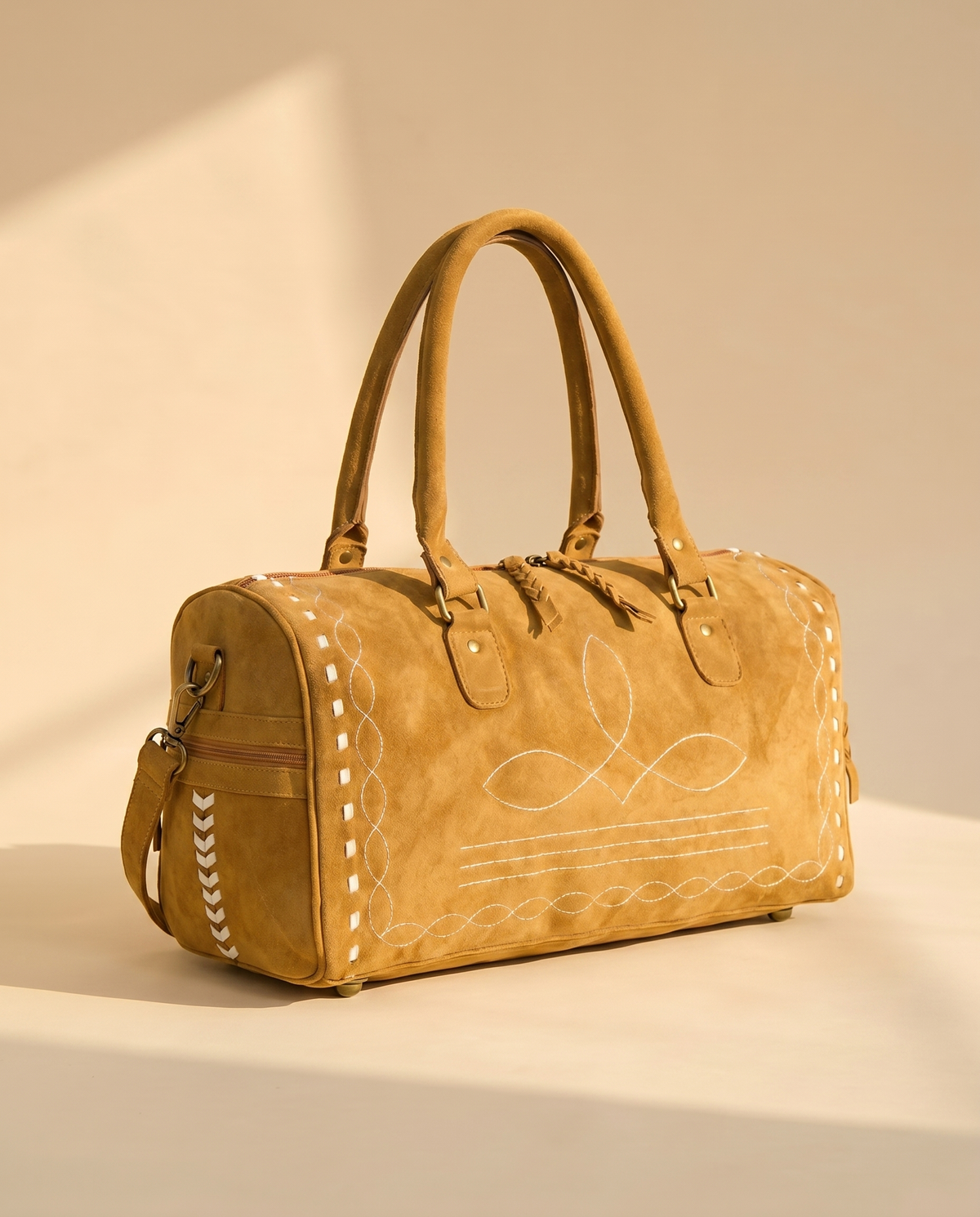 Tan suede duffle with buckstitched end panel, side view