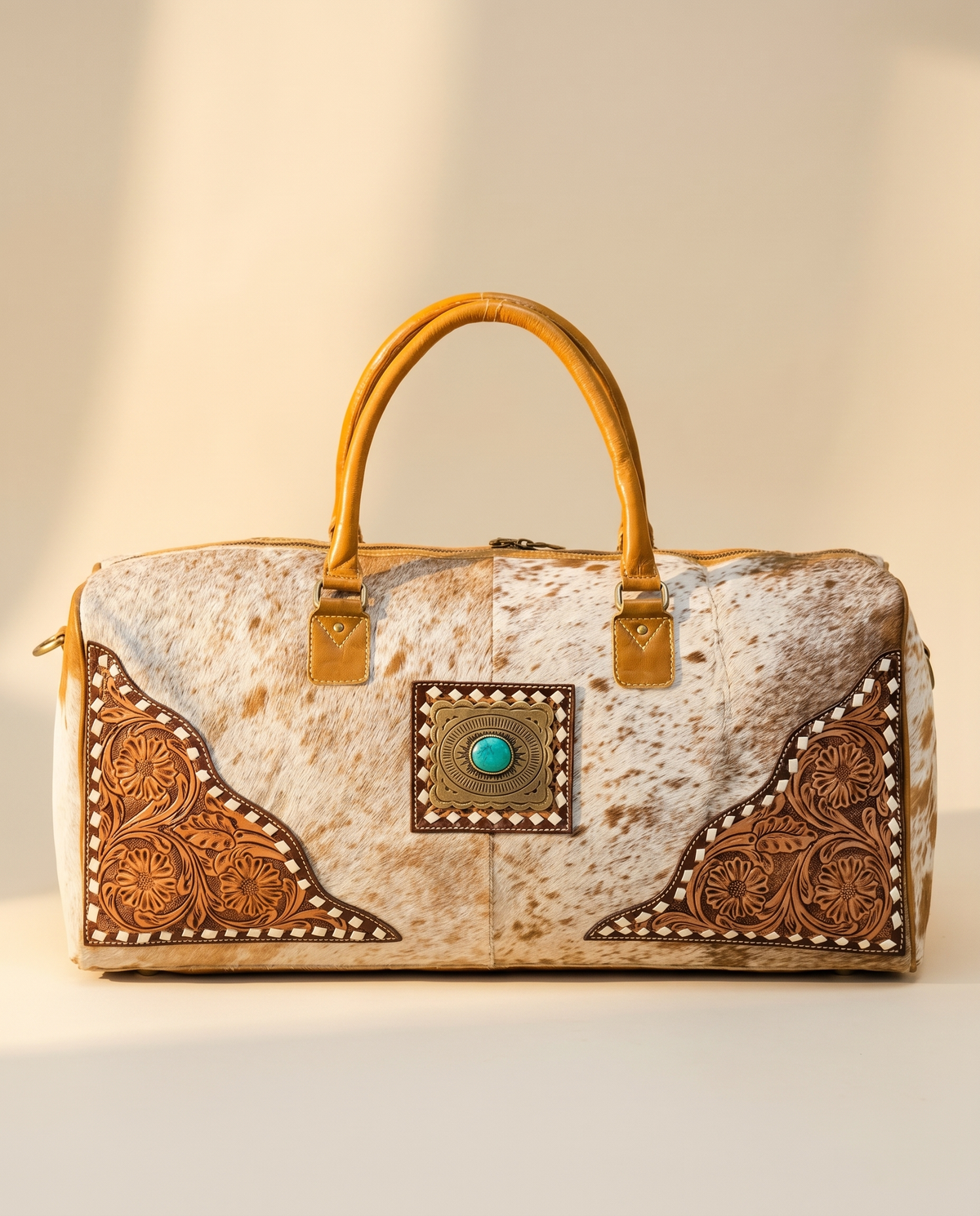 Speckled tan hair-on duffle with tooled floral corners and turquoise concho, front view