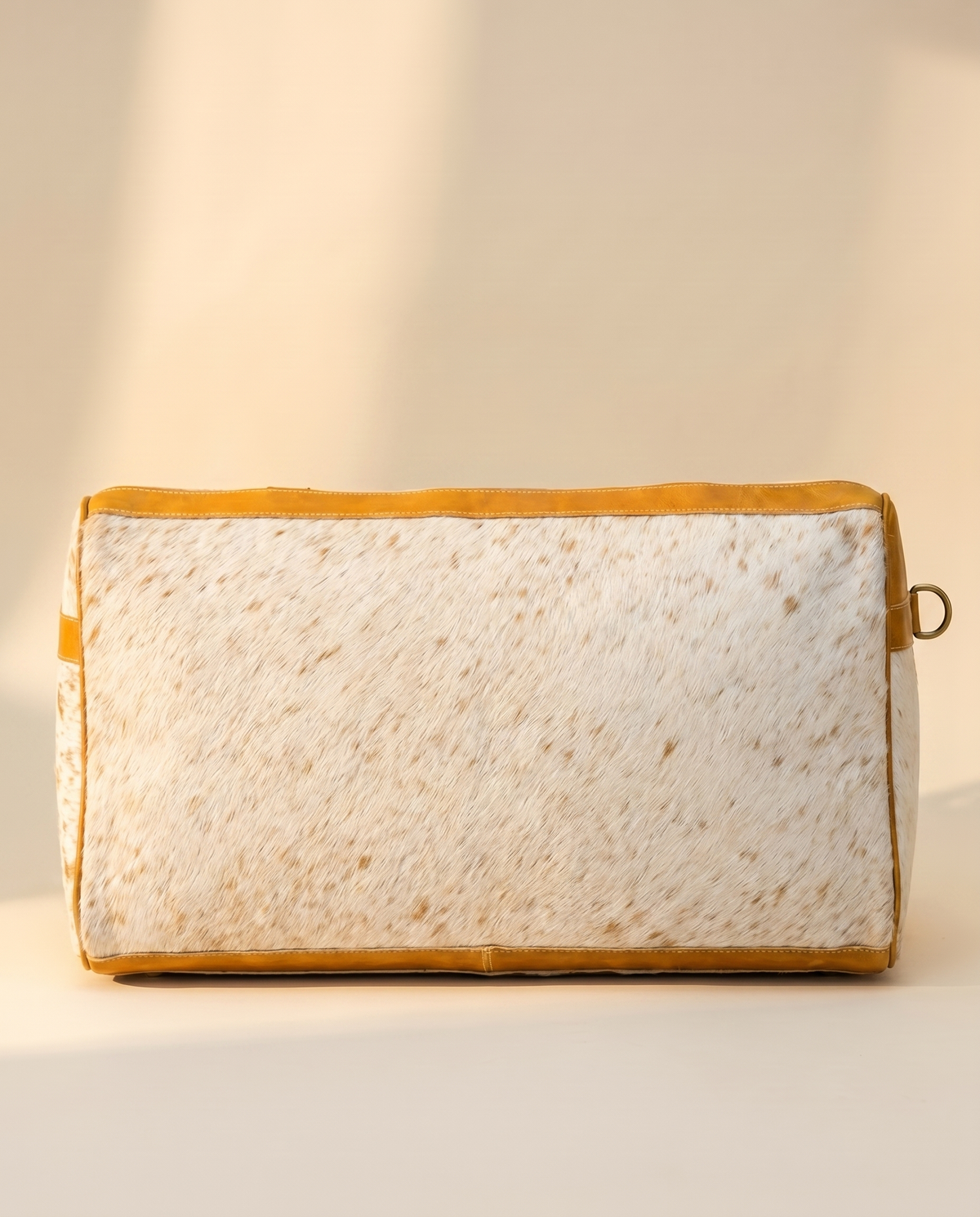 Back of speckled tan hair-on duffle with tan leather trim