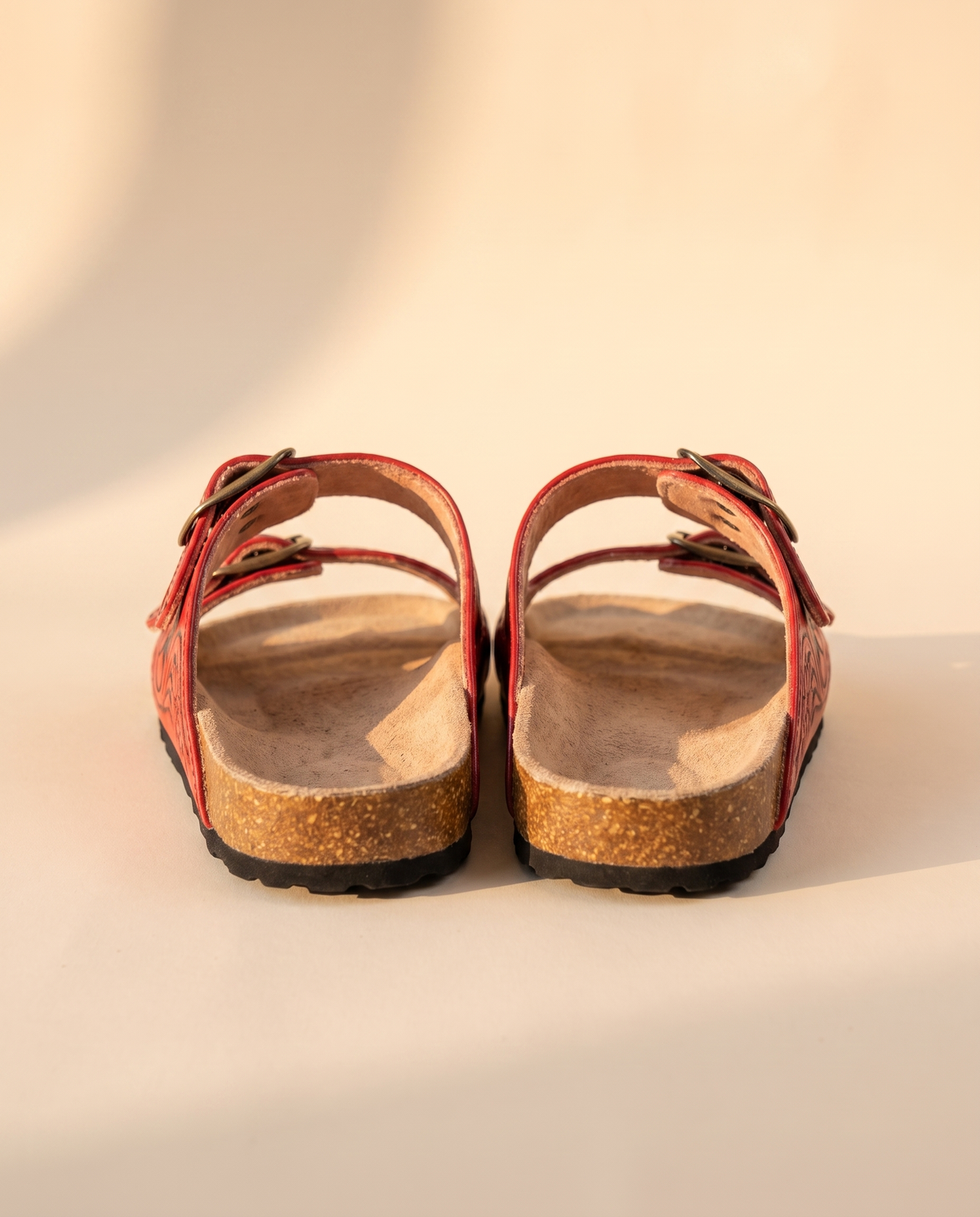 Back view of red diamond tooled leather slide sandals showing cork heel