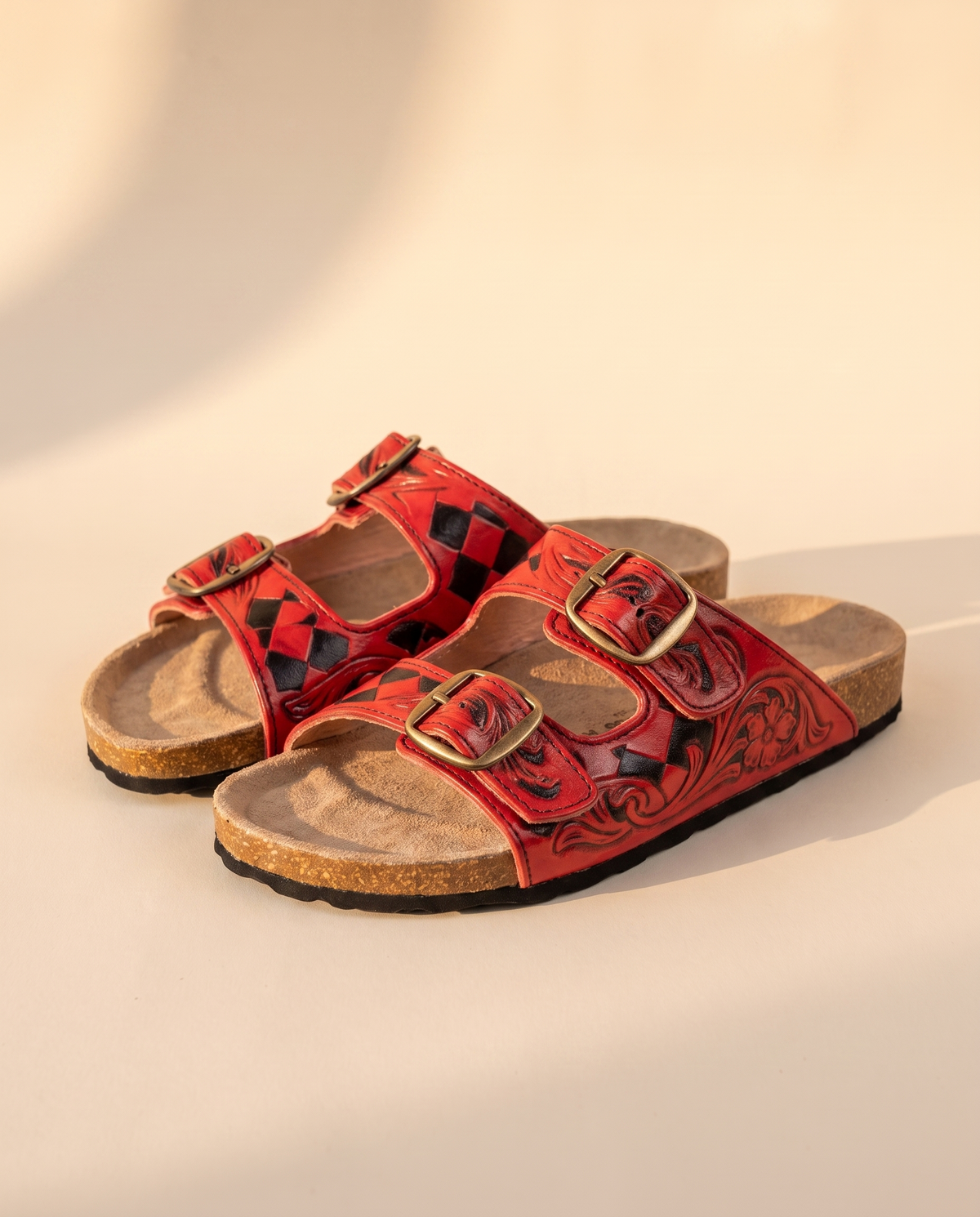 Red diamond tooled leather slide sandals, angled view