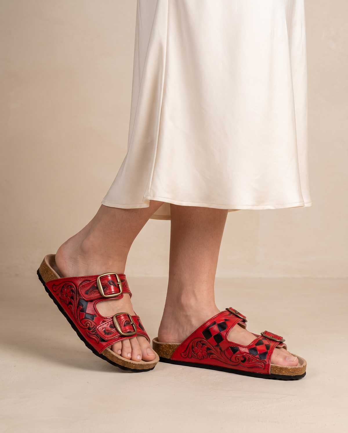Woman wearing red diamond tooled leather slide sandals