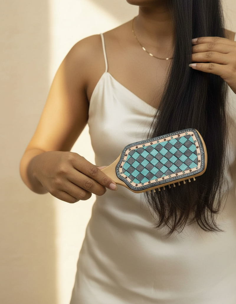 Woman holding the turquoise checkerboard hand-tooled leather hair brush