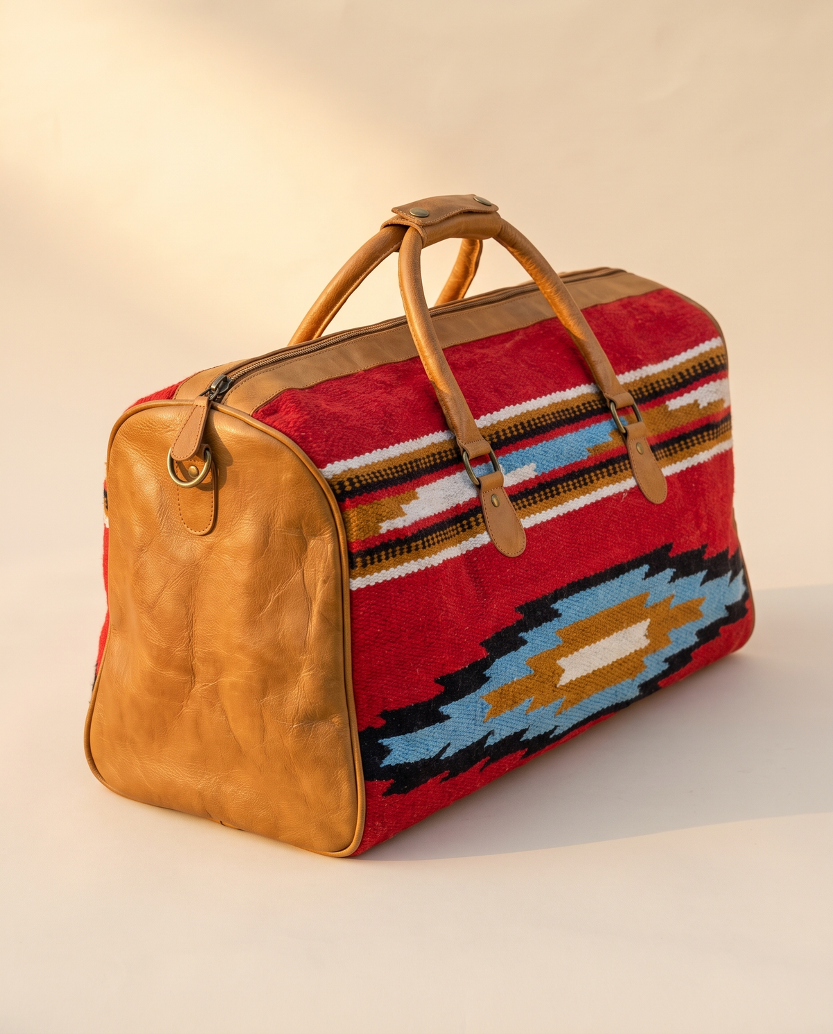 Red kilim weekender with tan leather end panel, angled view