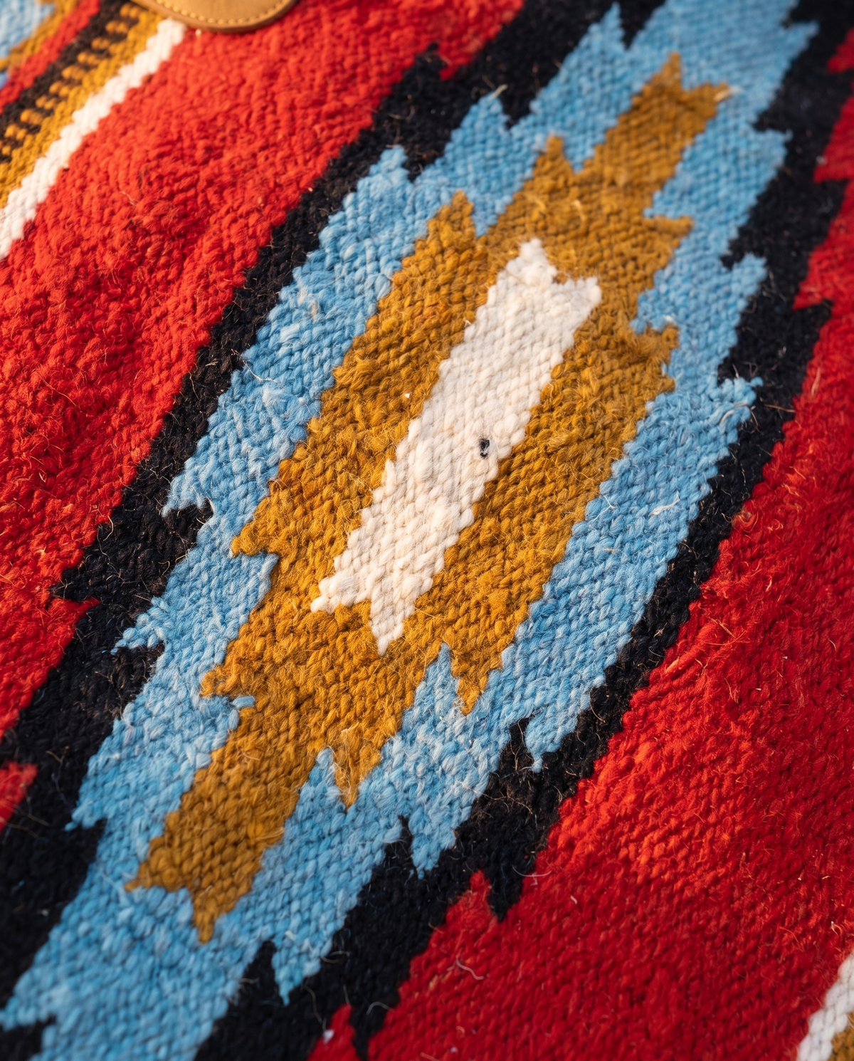 Detail of blue, mustard and ivory diamond woven into red kilim