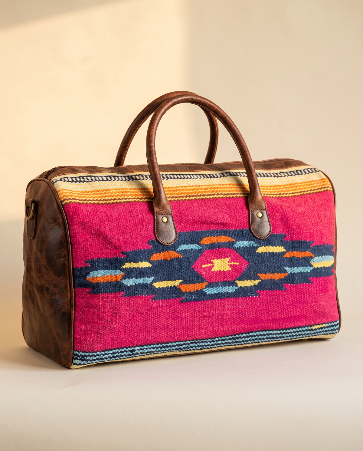 Fuchsia kilim duffle with navy diamond motif and dark brown leather, front view