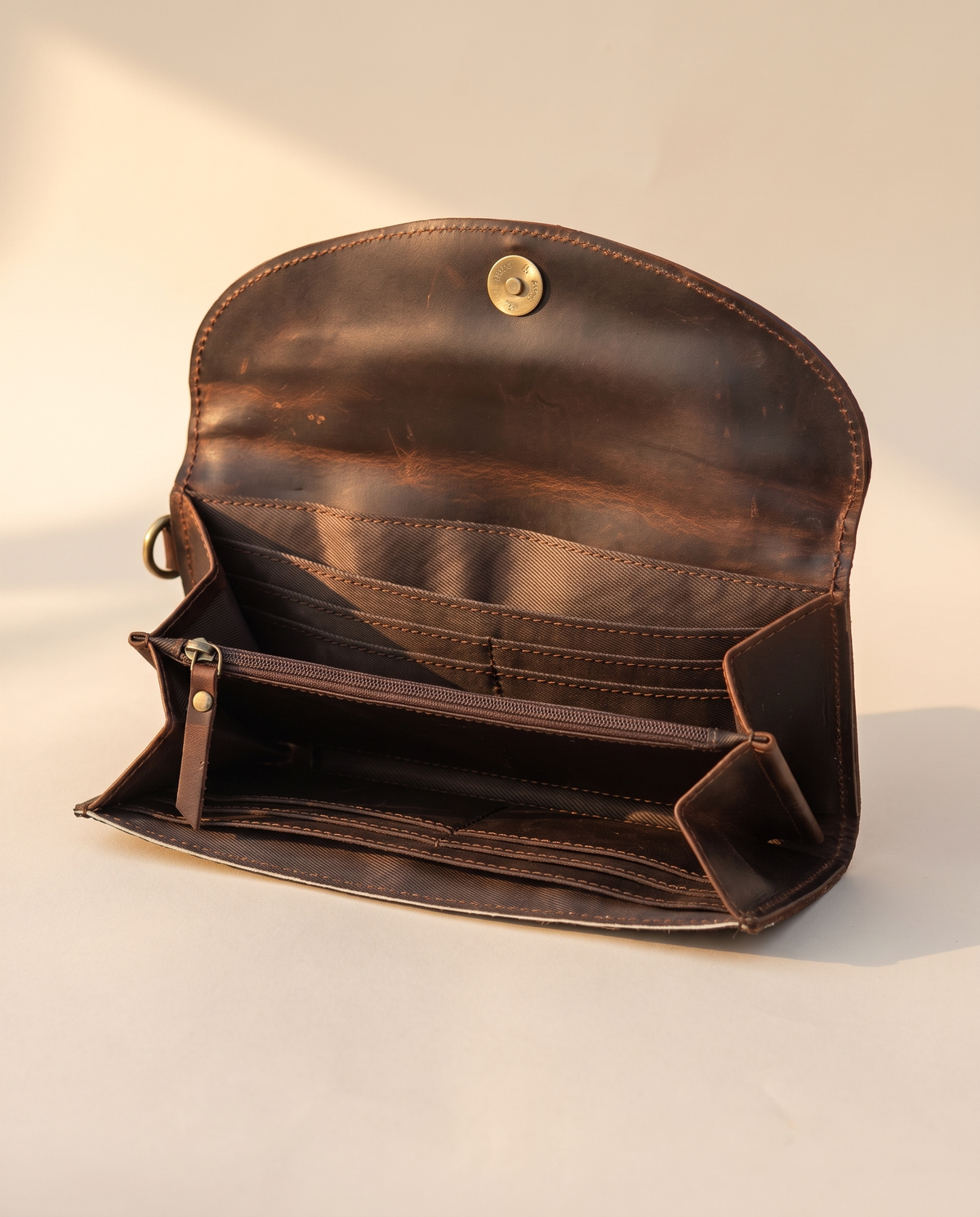 Brown cowhide wallet with curved hand-tooled flap, open interior view, by Ya Qalbi