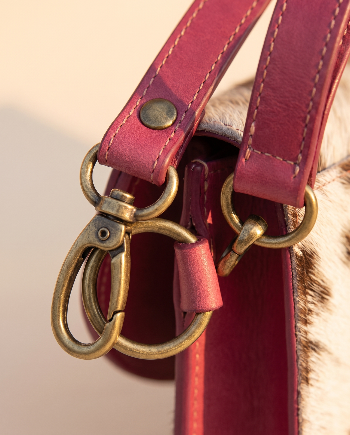 Pink cowhide wallet with curved hand-tooled flap, angled view, by Ya Qalbi